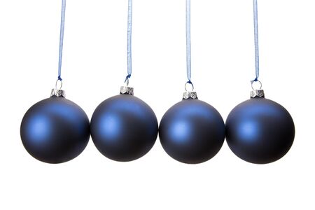Four blue christmas baubles hanging in horizontal row isolated on white backgroundの写真素材