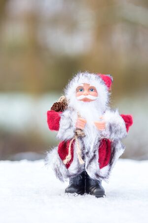 Santa Claus figurine standing in snow outsideの写真素材