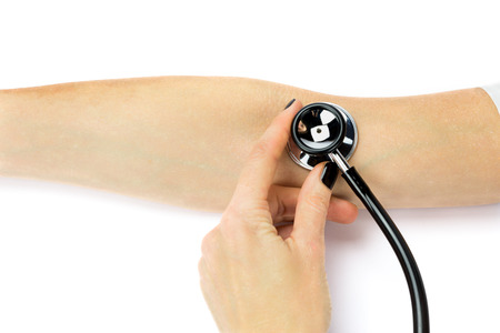 Female doctor holding stethoscope on patient's arm or blood pressureの写真素材