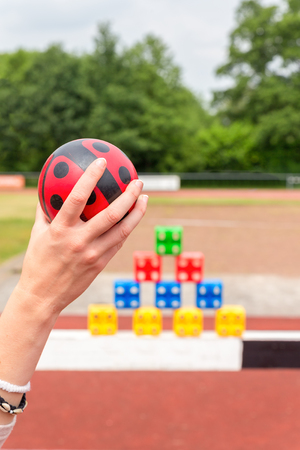 Girls arm with ball to throw at colored blocks as a gameの写真素材
