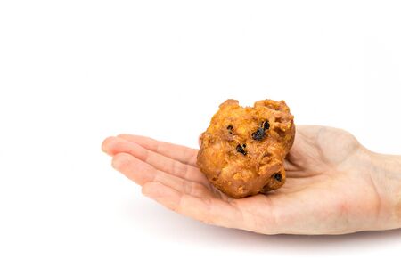 Female hand palm showing fritter or oliebol isolated on white background