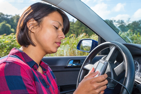 European woman operates digital route planner in carの写真素材