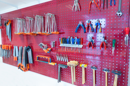 Many tools hanging at pegboard in classroom of school