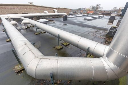 Metal pipes for ventilation system on flat roof of schoolの写真素材