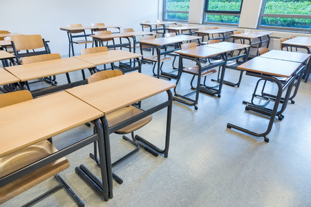 Rows of tables and chairs in classroom on high schoolの写真素材