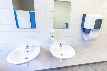 Toilet room for boys with sinks, towel dispenser and mirrorsの写真素材