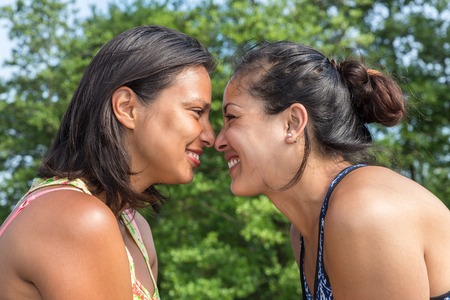 Portrait two young friends noses touching in natureの写真素材