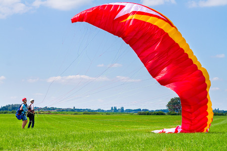 Paragliding instructor with boy preparing mattress flyerの写真素材