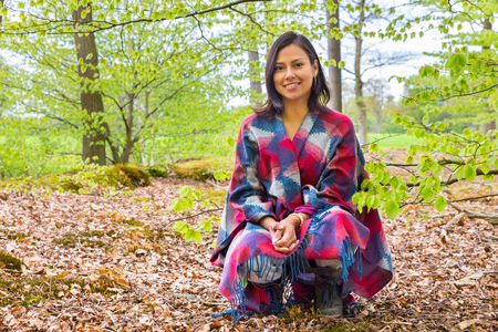 Young colombian woman sitting in dutch spring forestの写真素材