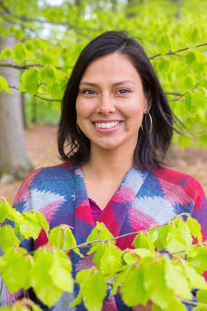 Portrait colombian woman with green beech leaves in spring seasonの写真素材