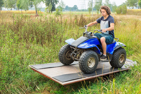 Young caucasian man driving quad on balanceの写真素材