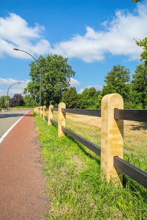 Fence along bike path and road in the Netherlandsの写真素材