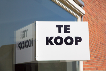 White marketing board on window of home with text Te Koop or For Saleの写真素材