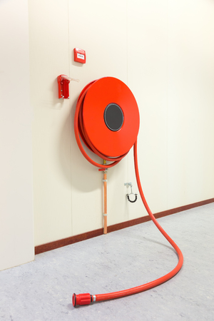 Red fire hose in building to fight a fireの写真素材