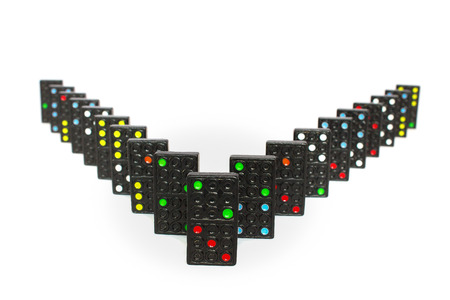 Black dominoes  lined up in V-shape isolated on white backgroundの写真素材