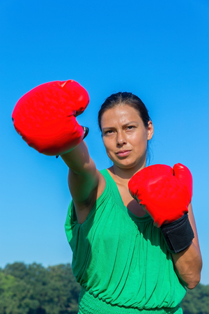 Young colombian woman wears red boxing gloves outdoorsの写真素材