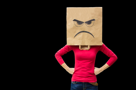 Angry woman carries paper bag isolated on black backgroundの写真素材