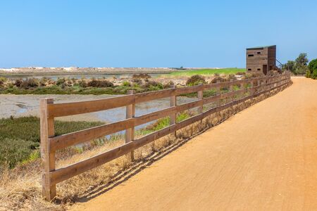 Portuguese coastal area with sandy path, wooden fence and hutの写真素材