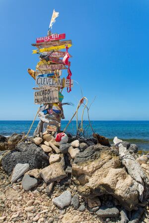 Signpost with stones at beach with blue ocean on island Bonaireの写真素材