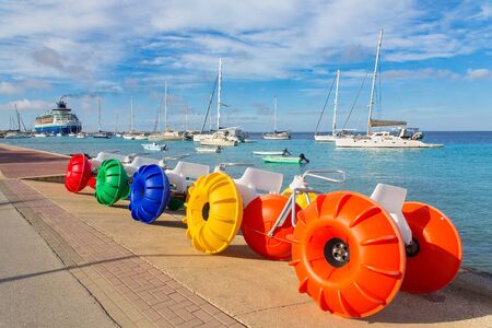 Colorful pedal boats and sailing boats by the sea water with boulevardの写真素材