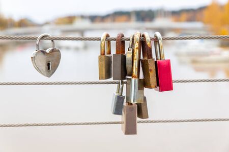Group of locks hanging on Finnish bridge as symbol of friendshipの写真素材