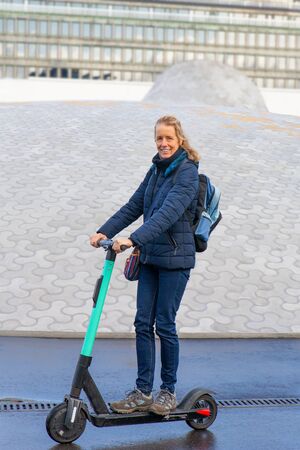 Woman driving electric scooter on the road in Finlandの写真素材