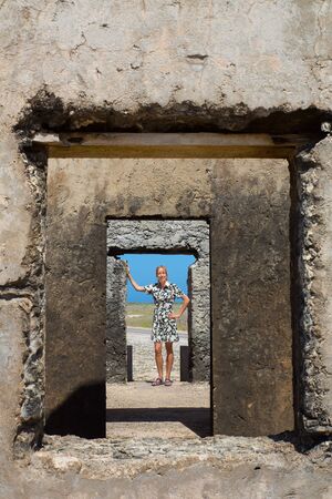 Caucasian woman is standing in doorway of historic building at Bonaireの写真素材