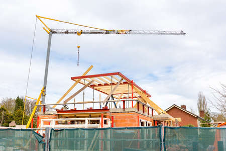 Building site with crane and house under constructionの写真素材