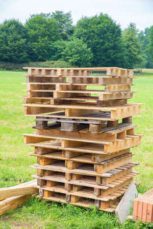 High stack of wooden pallets in Dutch pastureの写真素材