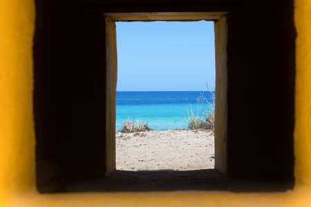 look through window in window with blue sea view on island Bonaireの写真素材