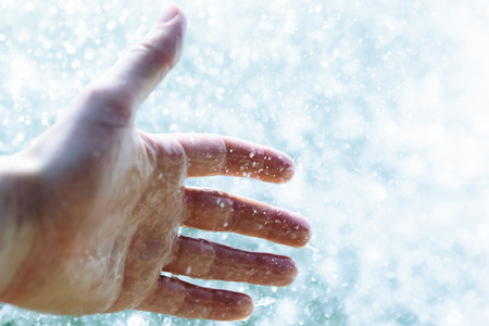 A hand sticking in to the water during a boat rideの写真素材