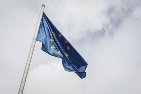 Low angle view of european union flag against cloudy skyの写真素材