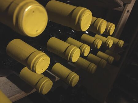 Wine bottles with yellow cap in rack at cellarの写真素材