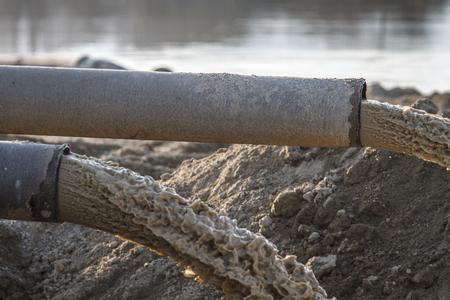 industrial effluent, pipeline discharging liquid industrial waste into a riverの写真素材
