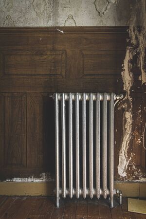 Old radiator in old and ruined abandoned house.の写真素材