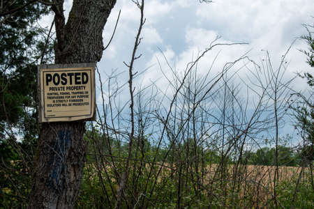 A sign warns against trespassing and hunting on private land.の写真素材