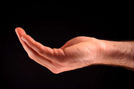 A cupped hand in front of a black background.の写真素材
