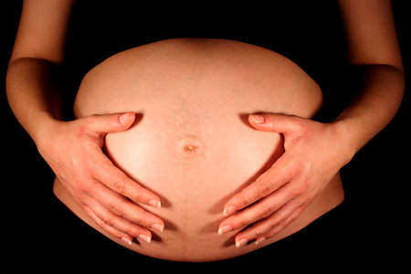 A pregnant woman with her hands on her stomach.の写真素材