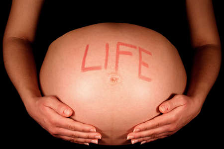A pregnant woman with the word "life" written on her stomach.の写真素材