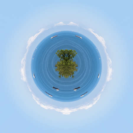 Polar coordinates, a circular image of the blue sea, clouds above the horizon, and cargo ships. In the foreground-the tops of green trees. Russia, Black Sea coastの写真素材