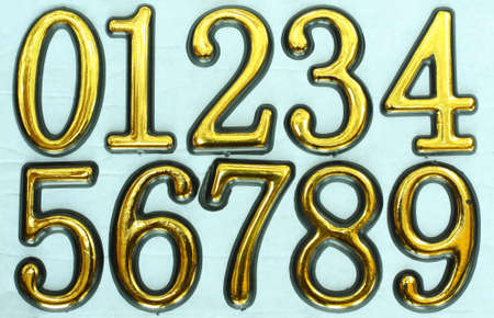 Golden bright numbers on a light blue background. の写真素材