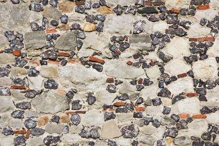 Multicoloured stone background of a building exterior facade with different sizes, colours and...