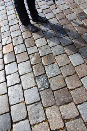 Man with his shadow on old cobblestone street in Nuremberg, Germany の写真素材