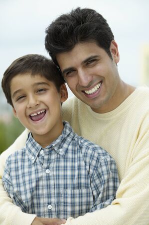 Portrait of a young man holding a young boyの写真素材