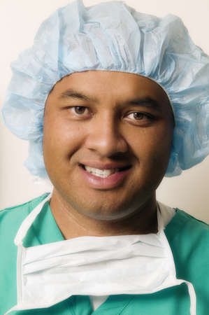 Portrait of a mid adult male doctor in full scrubs smiling
