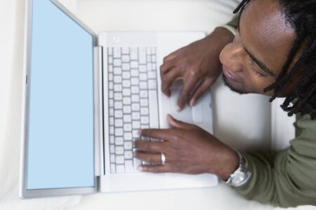 High angle view of a young man working on a laptopの写真素材