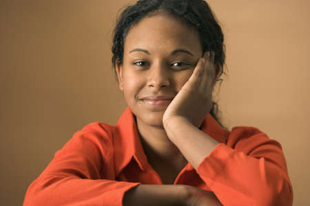 Portrait of a teenage girl smiling with her hand on her cheek