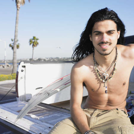 Portrait of a young man sitting on a pick-up truckの写真素材