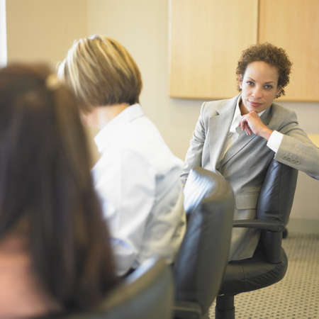 Three businesswomen discussing in a board roomの写真素材