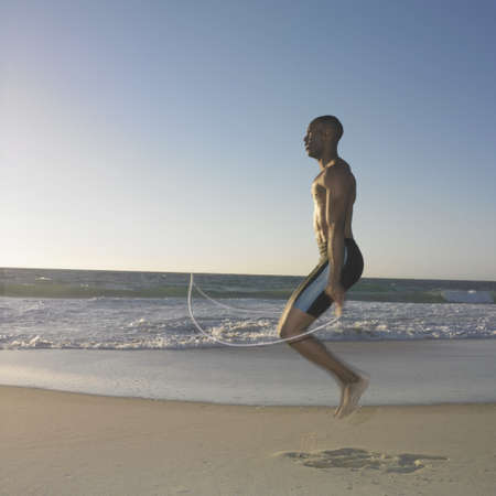 Side profile of a young man exercising with a jump ropeの写真素材